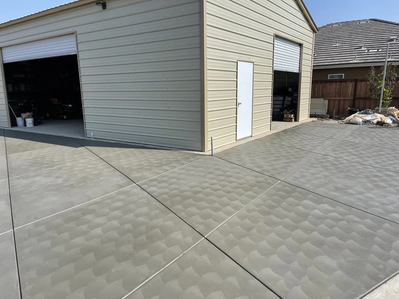 Stamped concrete apron in front of a metal workshop